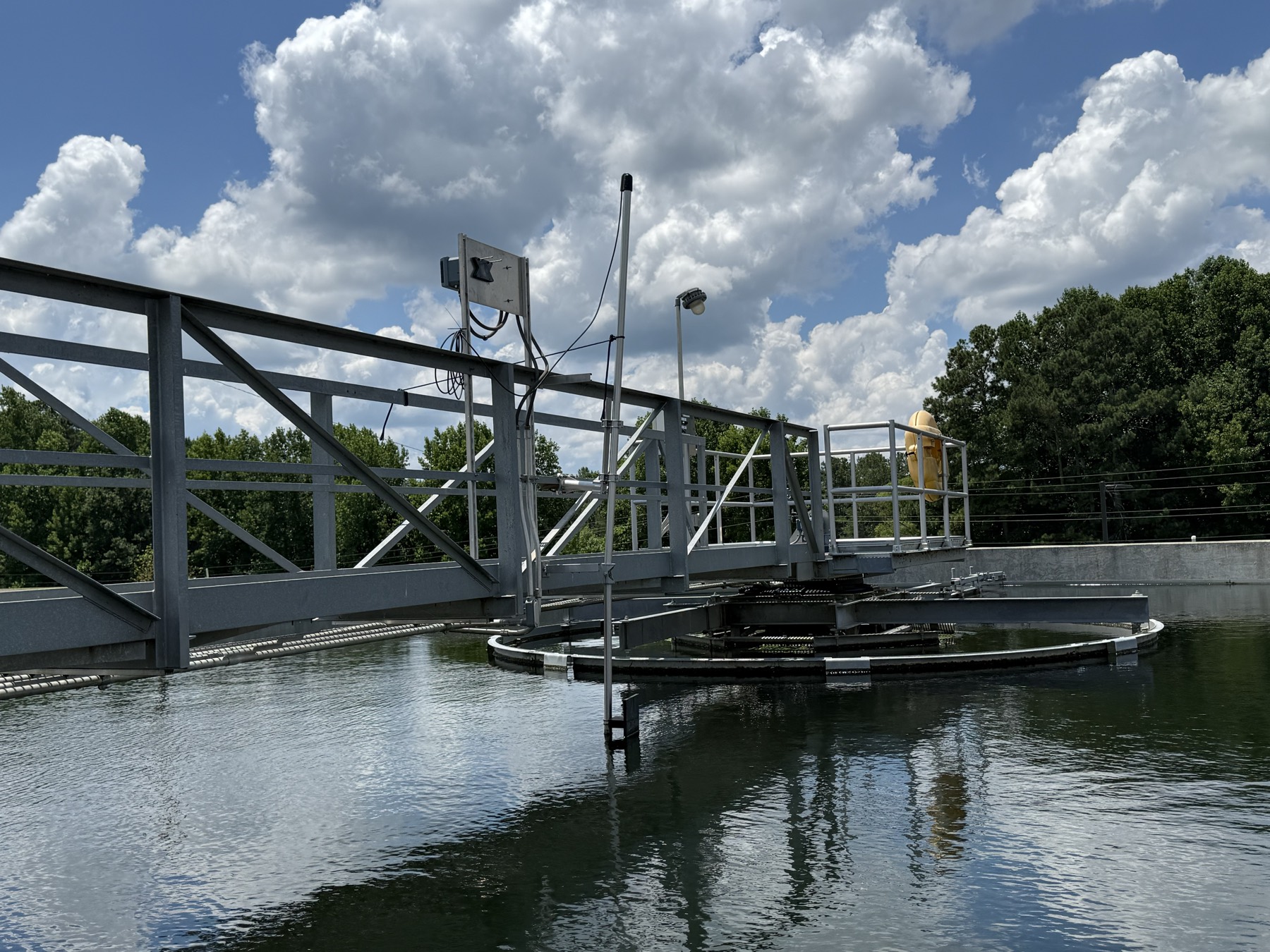 Wastewater clarifier bridge with telemetry antenna and control panel
